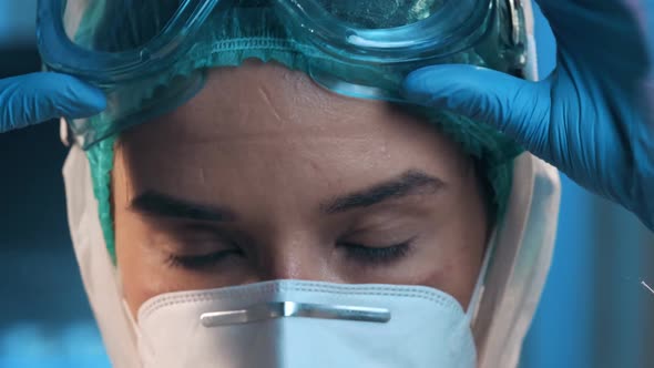 Doctor takes off glasses and a protective mask and shows the wounds rubbed