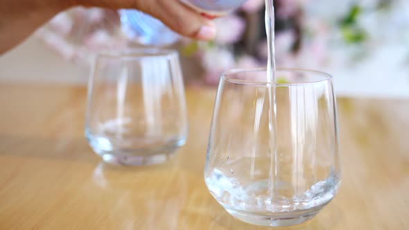 Pouring Water in a Glass on Table