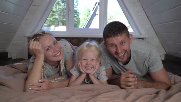 Happy Family with One Child Girl at Home on the Bed