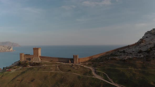 Wonderful Ancient Genoese Fortress with Towers and Stone Walls on Hill Top Below the Sea Under Blue