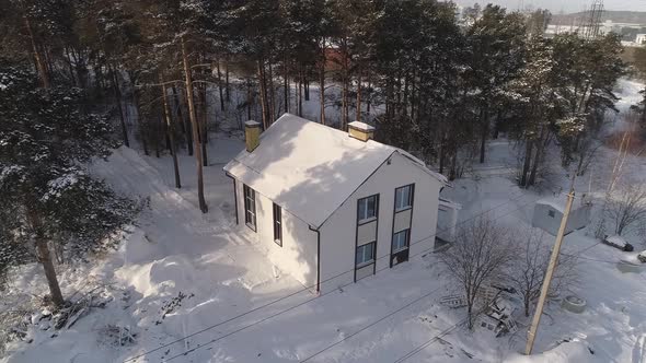 Drone shot of new white modern residential house at winter near the forest 08