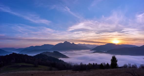 Fog in the valley in a beautiful mountain landscape. Day to night transition.4K