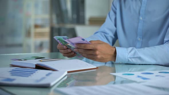 Man Planning Budget, Counting Euro in Office, Small Business Income Distribution