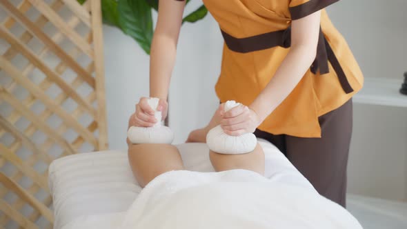 Close up of young girl feel relax during leg massage with herbal bags.