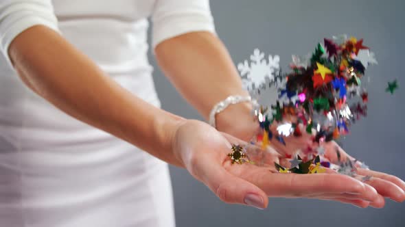 Mid-section of woman playing with confetti 4k