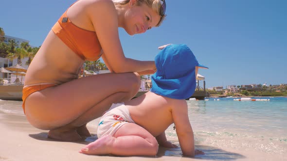 For the First Time, a Child Near the Ocean with His Mother Touches Salt Water 