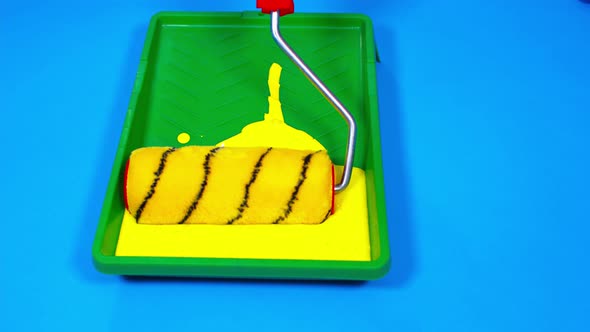 Close Up of Plastic Tray with Yellow Paint on Blue Background