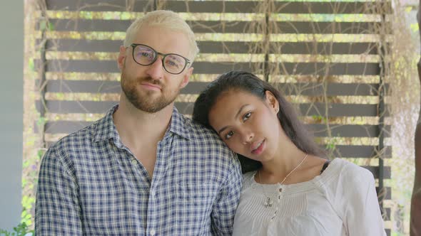 A Young International Interracial Couple in Love Looks Straight in To the Camera on a Sunny Day at