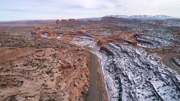 Aerial view above car driving on road through desert terrain in Moab Utah