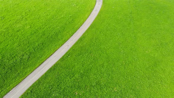 Serene road on meadow leading to idyllic Egg village, Switzerland, aerial tilt up reveal