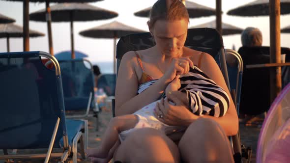 Woman Breastfeeding Baby at the Beach