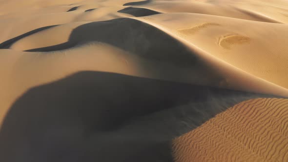  Cinematic Aerial of Strong Wind Blowing the Golden Sand From Dunes at Sunset