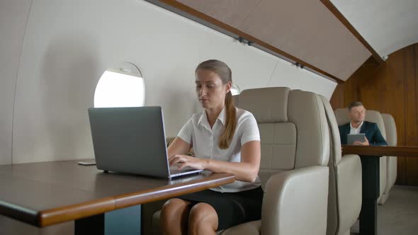 Businesswoman Using Laptop Computer on Airplane
