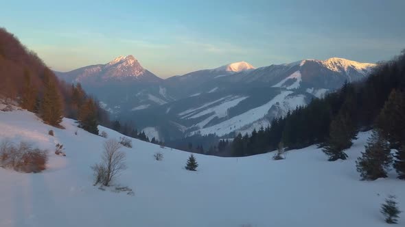 Fly over Winter Country Alpine Mountains in Cold Sunny Evening Aerial View Nature