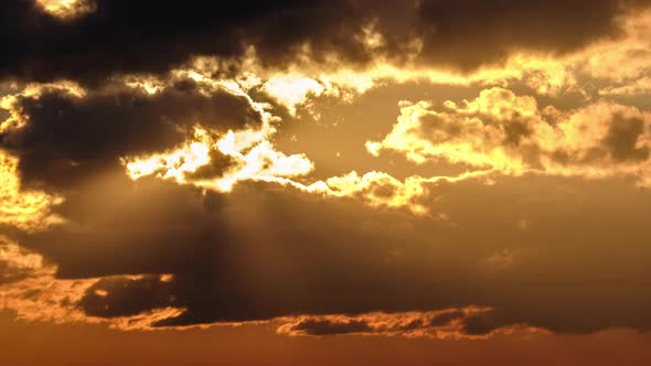 Dramatic Sunset with Sun Rays in Sky Through Orange Layered Clouds Timelapse