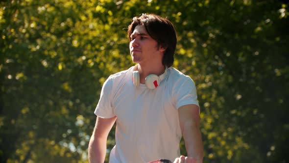 Young Man Riding a Bike and Checking His Phone Screen