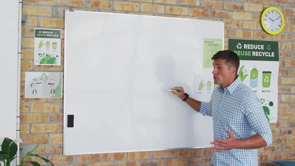 Caucasian male teacher standing at whiteboard giving an online lesson to camera