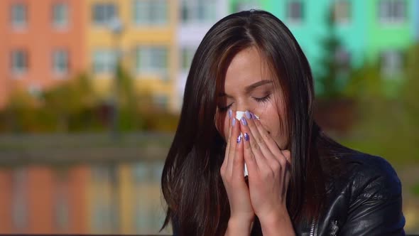 Young Attractive Girl, Caught a Cold on the Street, Wipes Her Nose with a Napkin.