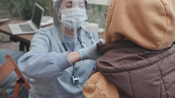 Medical Worker Examining Child at Refugee Camp