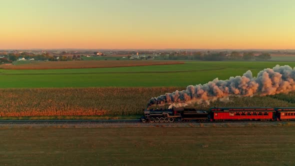Steam Engine and Passenger Cars at the Golden Sunrise with a Full Head of Steam