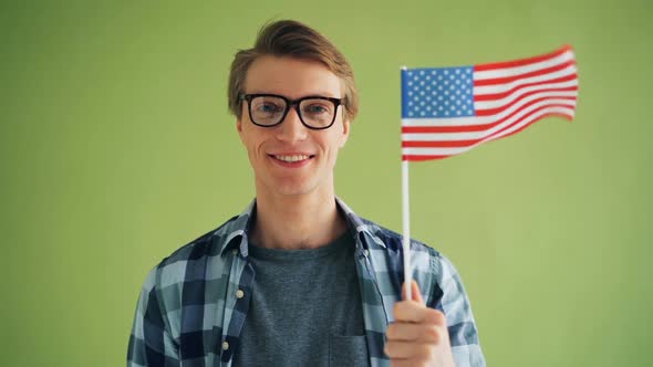 Slow Motion Portrait of Young Man with American National Flag Smiling