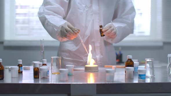 Man in Protective Workwear Set Fire To Thing on Table in the Laboratory, Slow Motion