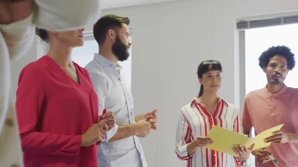 Diverse male and female business colleagues discussing at meeting in office