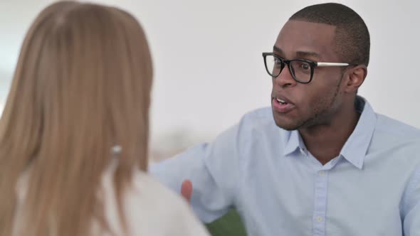 Rear View of Mixed Race Couple Having Conversation on Sofa