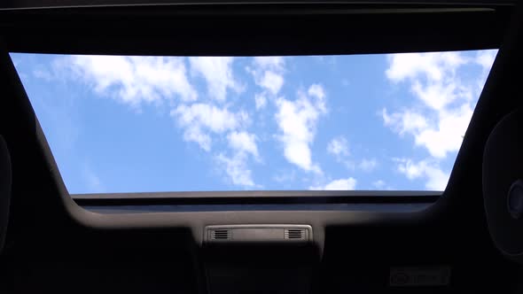 View at the Sky Through a Car Roof Window