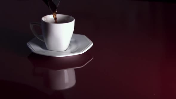 Coffee being poured into a white cup in slow motion