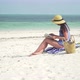 Young Caucasian Woman Reading Book On The Beach - VideoHive Item for Sale