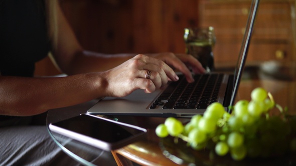 Beautiful girl typing on a laptop closeup