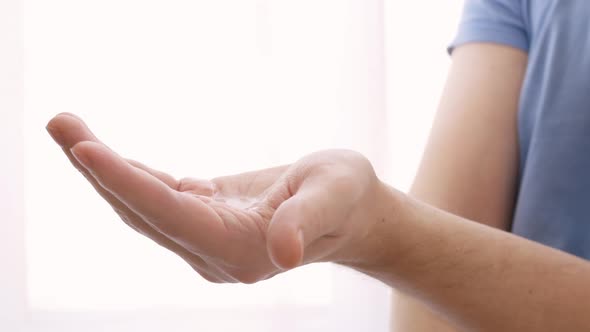 A Sanitizer is Poured Onto the Hand to Treat Infections to Prevent the Spread of Coronavirus