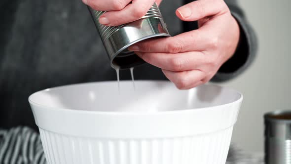 Opening canned white beans with can opener.