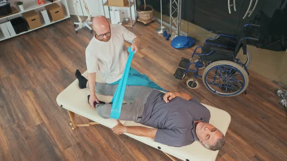 A Professional Physiotherapist Conducts Rehabilitation of a Patient