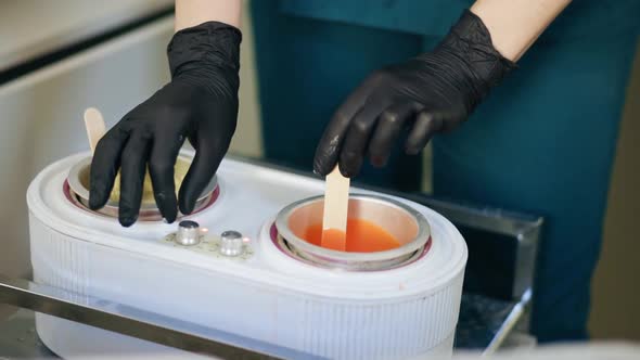 Female Master of Hair Removal Preparing Wax for Depilation