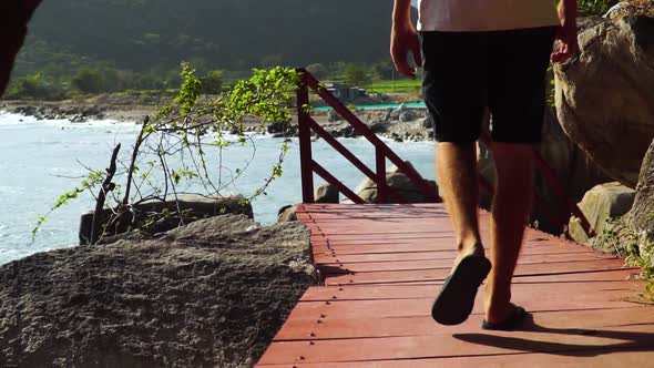 Tilt-up of man walking on wooden jetty in Hang Rai, Vietnam. Slow-motion