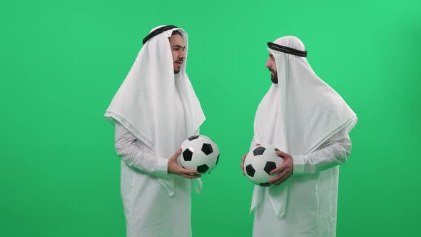 Two Arab Men in Traditional Clothes on the Background of a Chroma Key Mans Wearing Kanduras and Hold