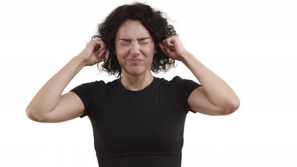 Young Woman with Curly Short Hair Wearing Black Tshirt Plug Fingers in Ears Shaking Head in Denial