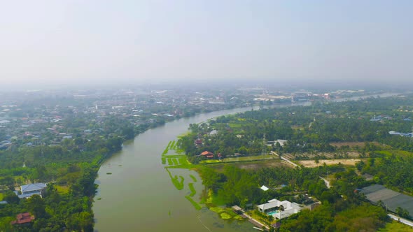 Aerial top view of curve of Chao Phraya River and forest trees and green mountain hills. Nature