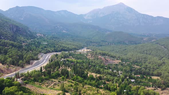 aerial drone overlooking the Taurus Mountains in Antalya Turkey as a highway passes through the gree