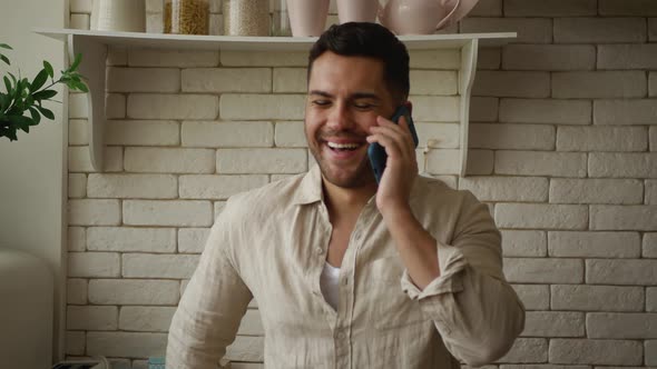 Smiling, cheerful man talking on the phone with someone 