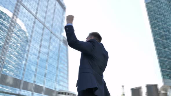 Businessman Celebrating Success Outside Office