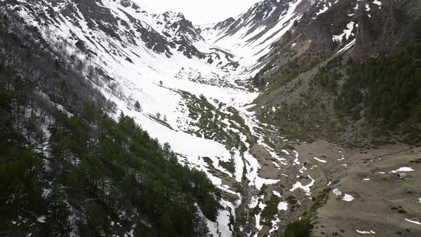 Aerial View of a Partially Snow Covered Gorge for a Late Spring Freeride