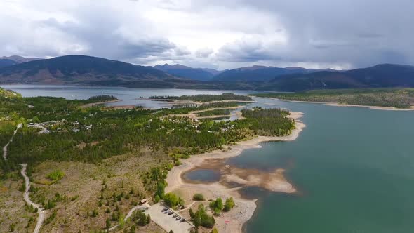 Aerial Over Lake with Scattered Islands and Mountains with Storm Clouds in the Distance