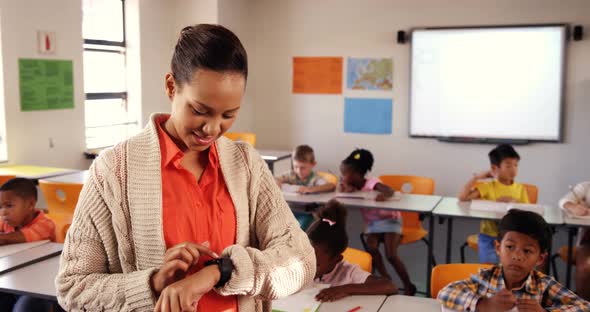 Teacher adjusting smart watch in classroom