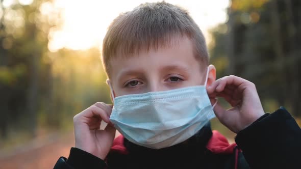 Child Boy Takes Off His Medical Mask Outdoors