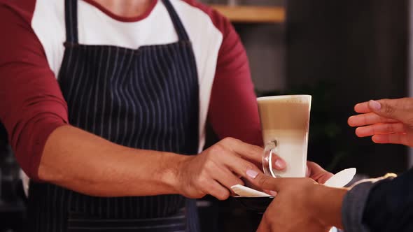 Close up of customer taking his coffee at counteer