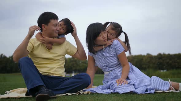 Lovely Asian Family with Siblings Relaxing at Park