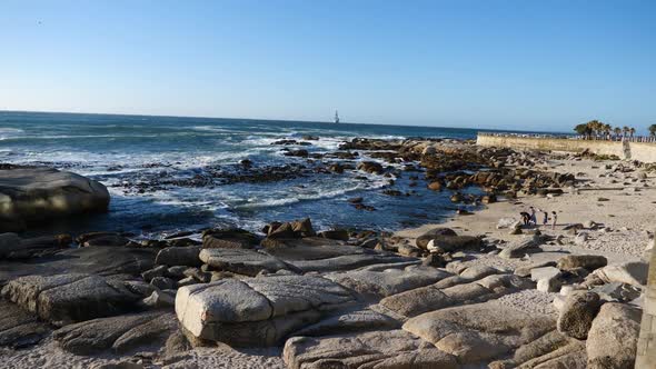 Wide shot of Bantry Bay, South Africa in late afternoon sunlight on a blue sky day at the Atlantic O